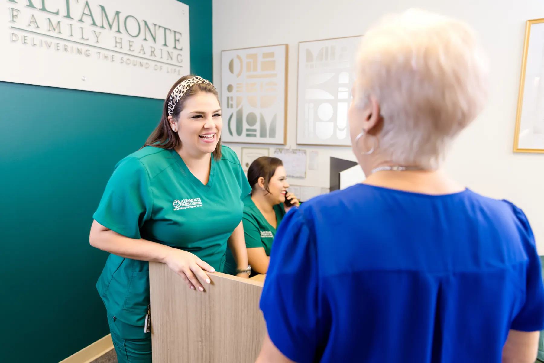 A Patient Care Coordinator welcoming a patient at the front desk