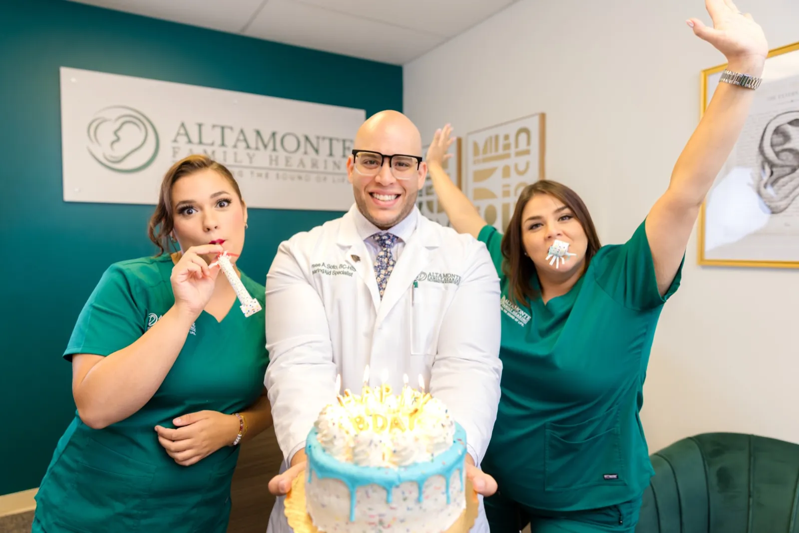 Grace, Jaysee and Francesca celebrating with a cake at the front desk