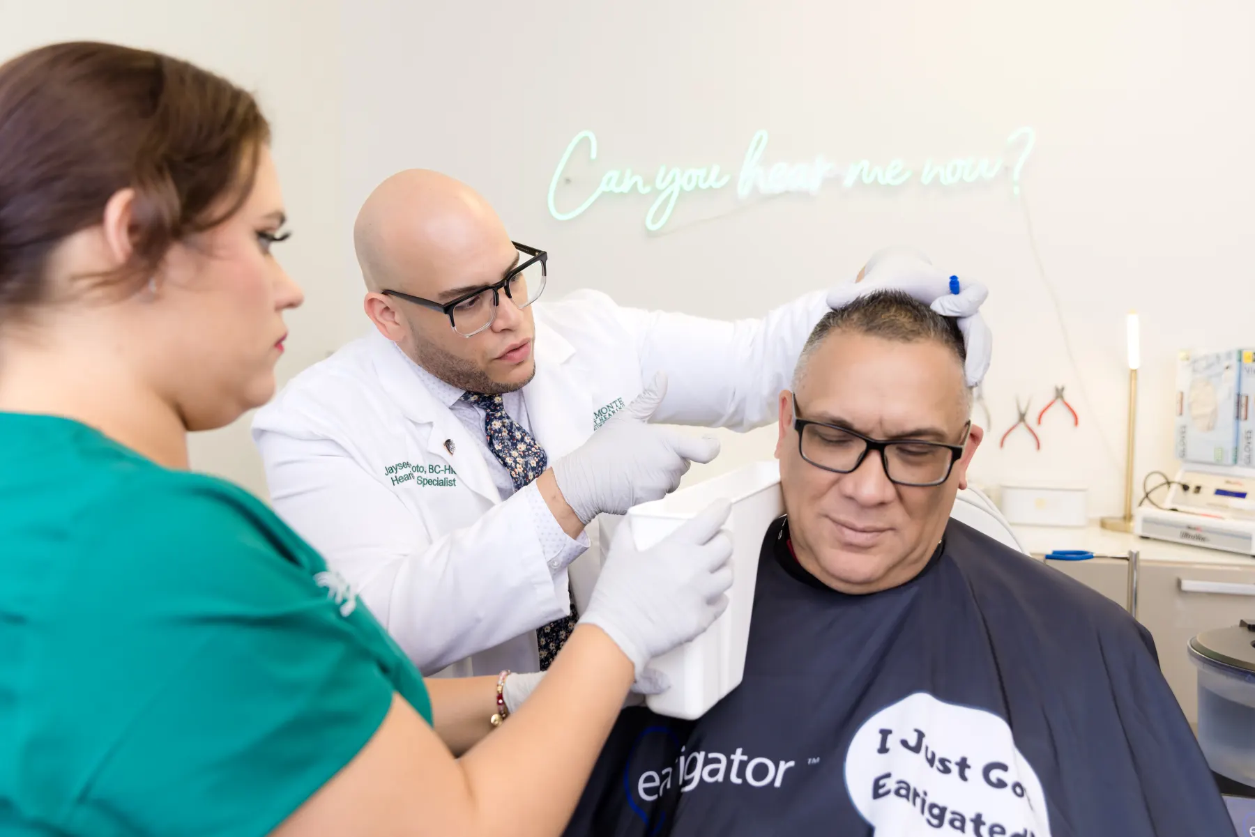 Jaysee removing earwax with the Earigator, a Patient Care Coordinator assisting