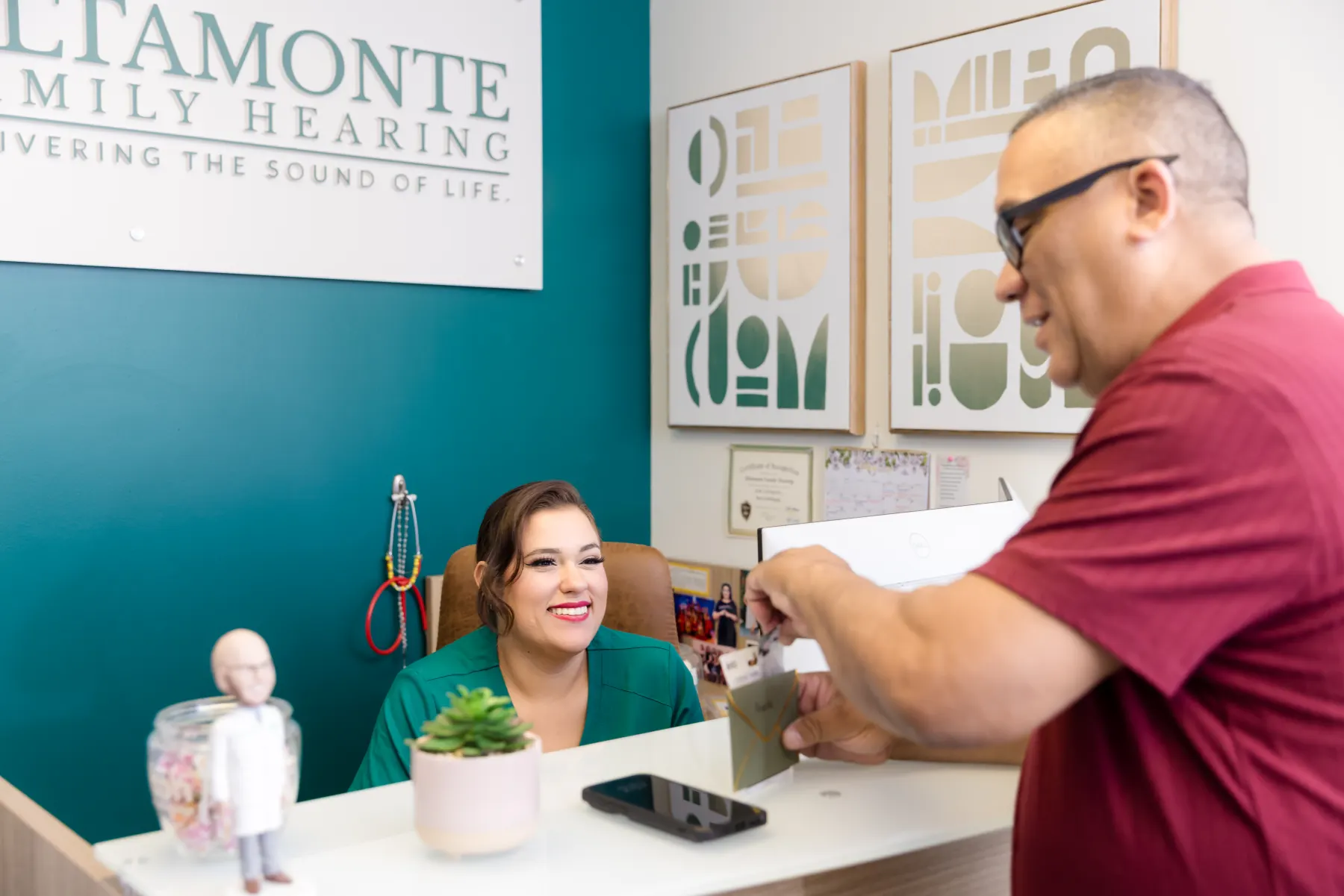 A patient chatting with one of our Patient Care Coordinators at the front desk
