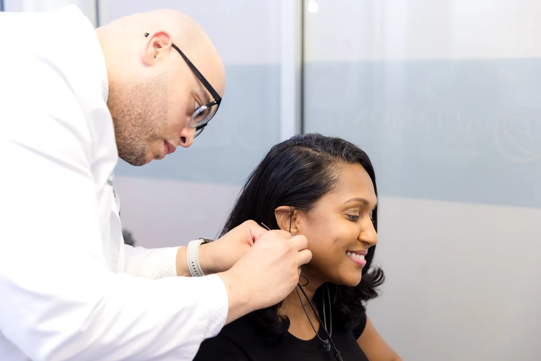 Jaysee checking the probe tube in a patient's ear during Real Ear Measurement