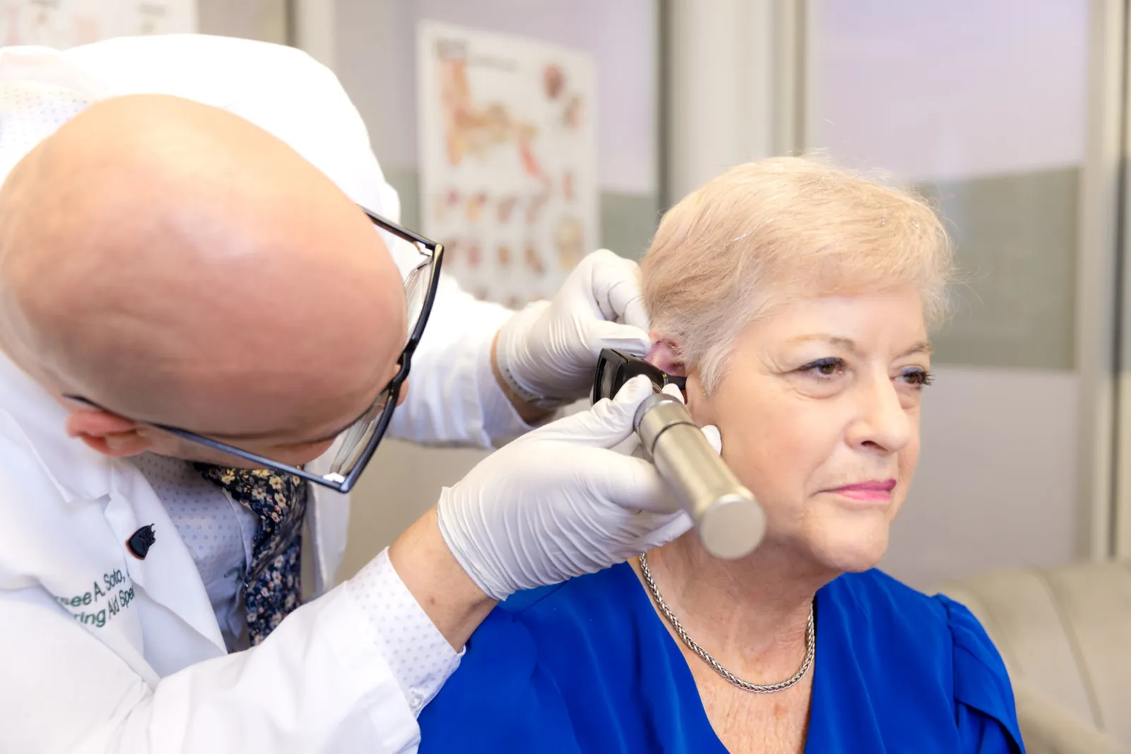 Jaysee looking into a patient's ear with a video otoscope