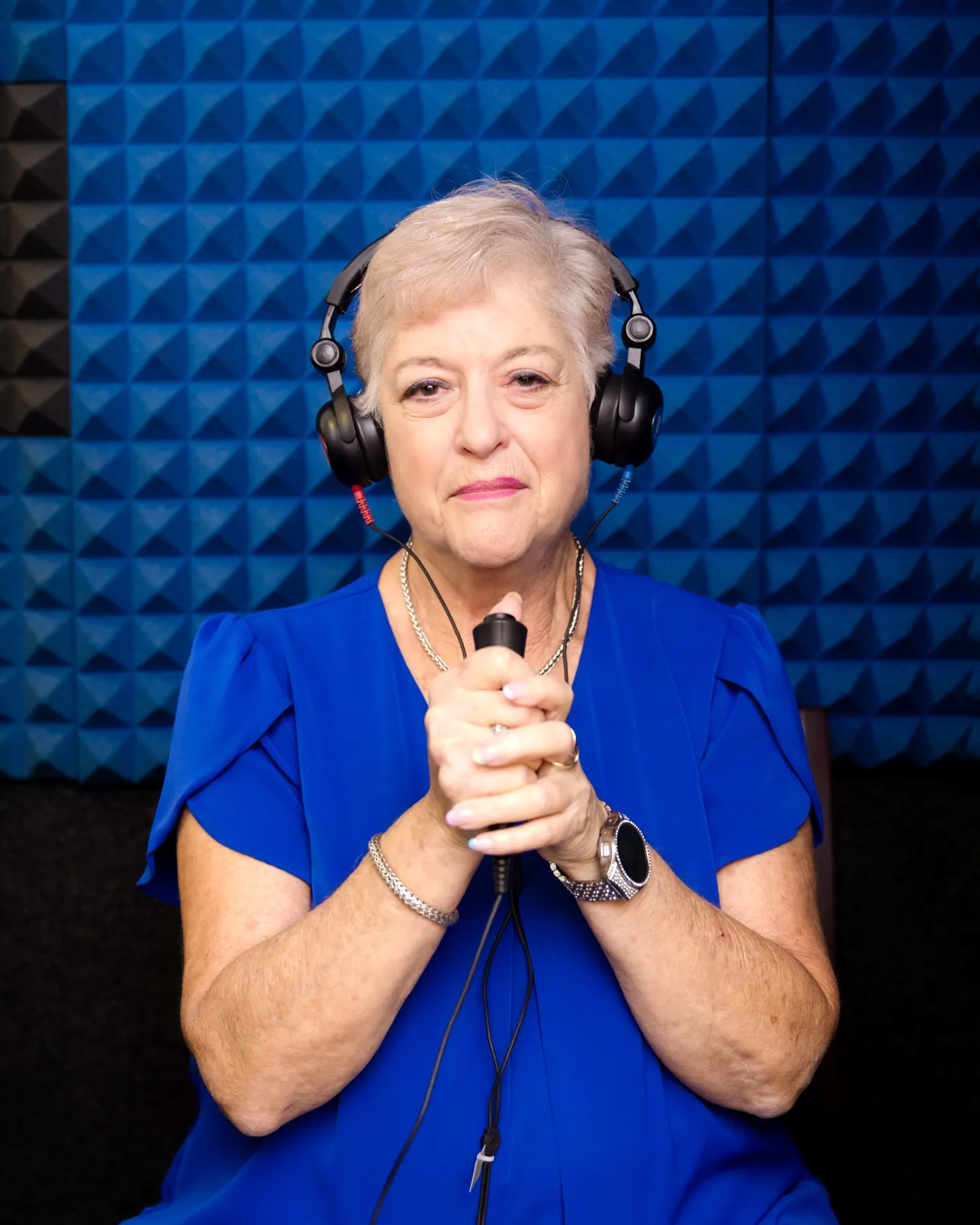 A patient in the sound booth wearing headphones, smiling