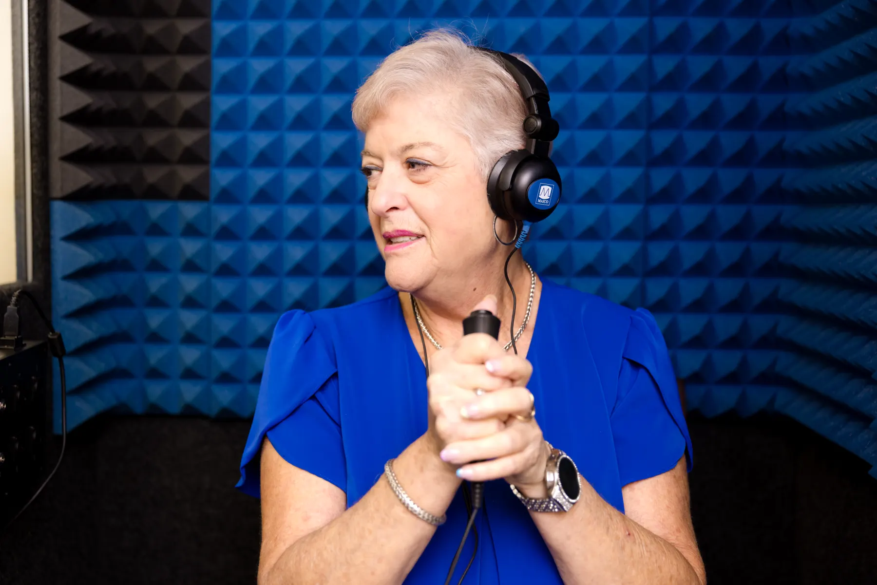 A patient in headphones in the sound booth, holding the response button