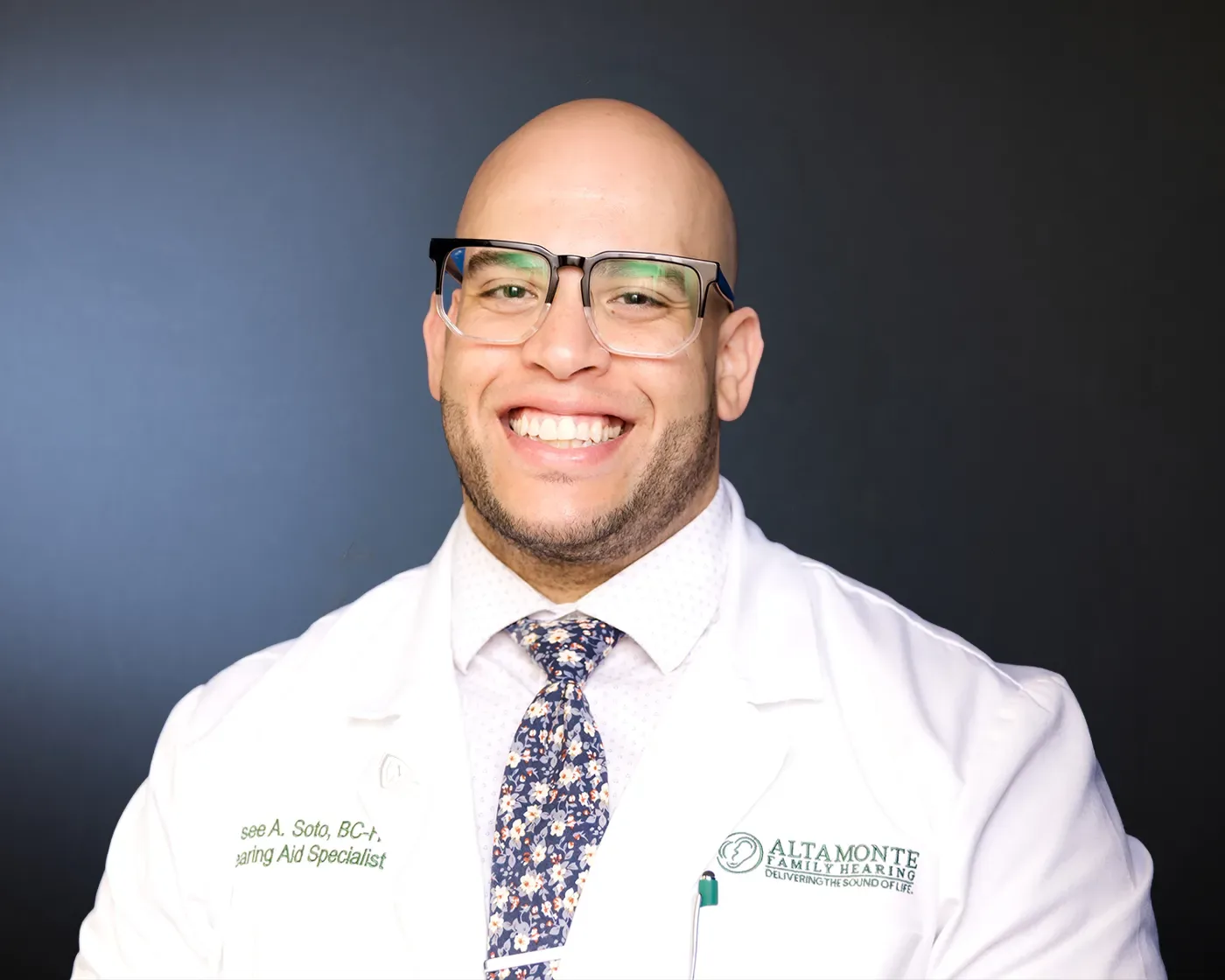 Jaysee Soto, HAS, BC-HIS, Owner and Hearing Aid Specialist, in his white coat